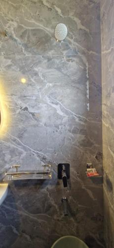 a bathroom with a marble wall and a sink at Villa Riviera in Covelong