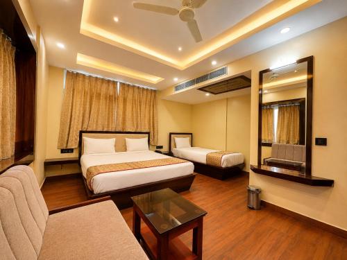 a hotel room with two beds and a couch at Hotel A One Luxury - Premium Stay Puri Beach in Puri