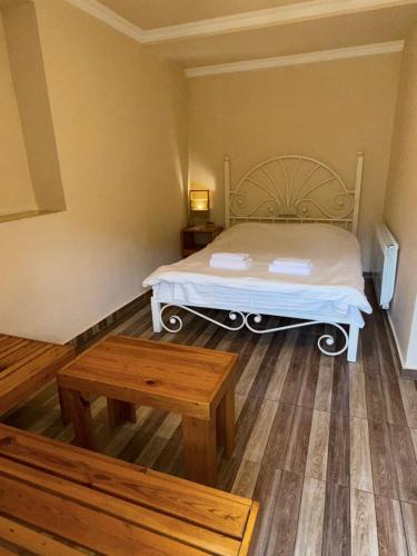 a bedroom with a bed and a wooden floor at Arami Guest House in Dilijan
