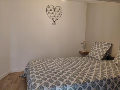 a bedroom with a bed with a heart on the wall at Studio le 174 in Mazan