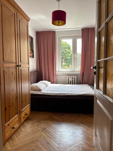 a bedroom with a bed and a window at Apartament centrum Szczytno Mazury in Szczytno