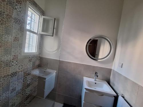a bathroom with a sink and a mirror at Super Appartement Sidi Rhal in Dar Hamida