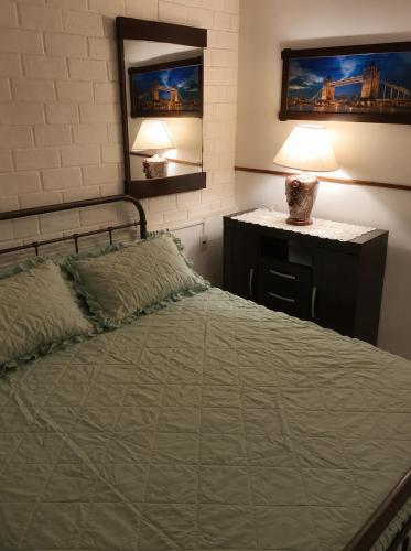 a bedroom with a bed and a table with a lamp at Casa Solymar completa 3 dormitorios 5 camas Hasta 6 personas RESERVAS SOLO CON SEÑA in Ciudad de la Costa