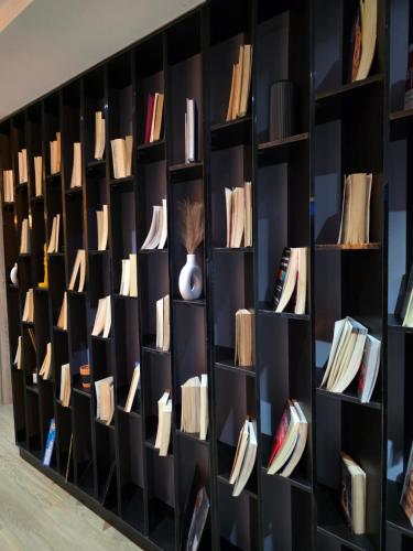 eine Bibliothek mit schwarzen Regalen voller Bücher in der Unterkunft Haus in Enugu