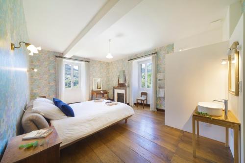 a bedroom with a bed and a sink in it at Chez Jeanne, superbe corps de ferme, vue imprenable in Issor