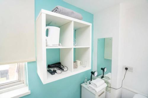 a bathroom with a white cabinet above a toilet at Budget En-suite Room in Coventry City Centre in Coventry
