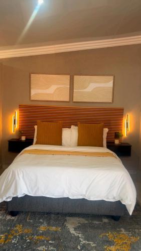 a bedroom with a large white bed with two pillows at Impèrio Boutique Guest Lodge in Siyabuswa