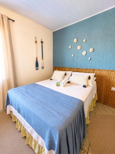 a bedroom with a bed with a blue wall at Pousada Surf na Guarda in Guarda do Embaú