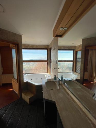a large bathroom with a tub and a sink at Hotel Peregrino Suites in Concepción
