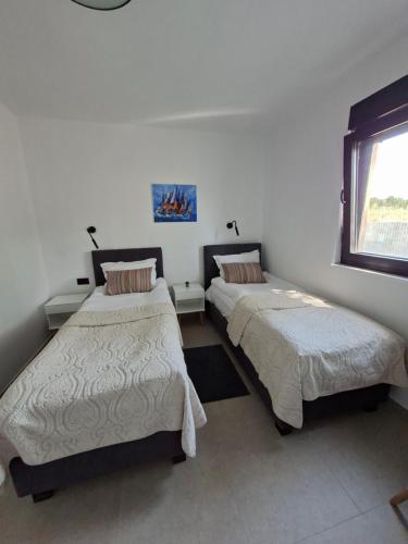 a room with two beds and a window at Vila Mila Private Pool Retreat in Radetići