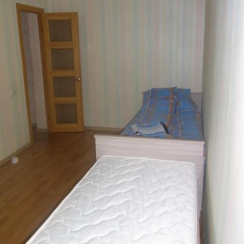 a white bed in a room with a door at Apartments Lenina-Mendeleevskiy in Tula