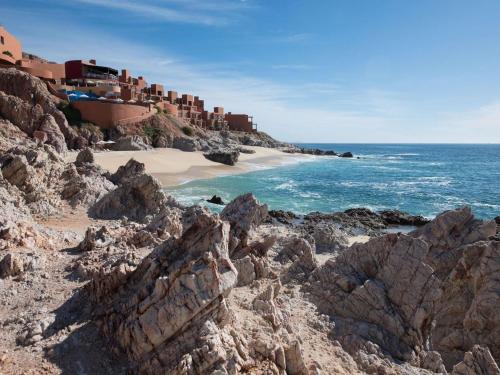 a beach with rocks in front of the ocean at Club Regina Los Cabos in San José del Cabo