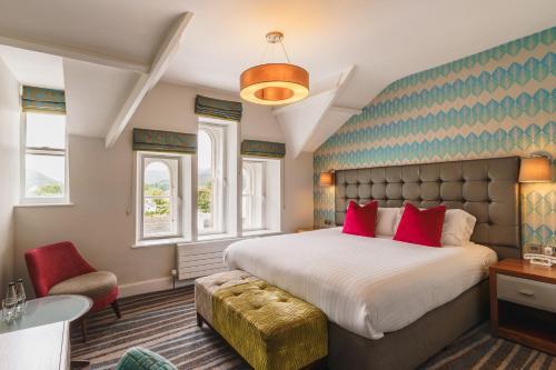 a bedroom with a large bed with red pillows at Inn on the Square in Keswick