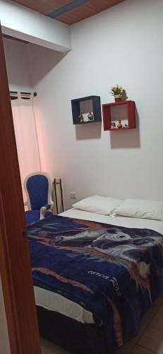 a bedroom with a bed and two pictures on the wall at Atardeceres in Puerto Rey