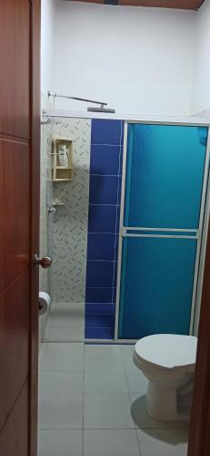 a bathroom with a toilet and a blue wall at Atardeceres in Puerto Rey