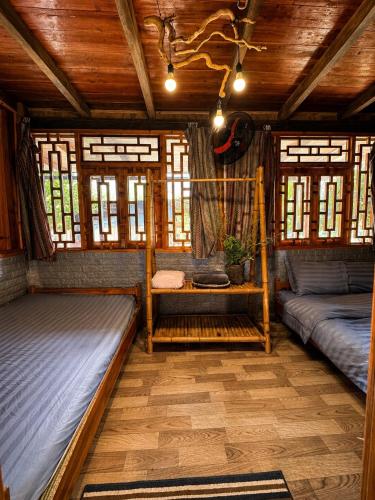 a room with two beds in a room with windows at Surelee Homestay & Sapa Trekking Tours by Local Path in Sapa