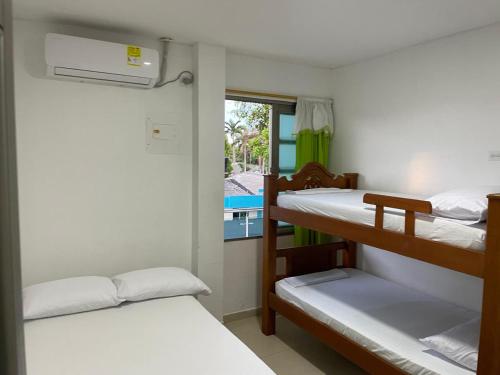 a room with two bunk beds and a balcony at Habitaciones Melany in Coveñas