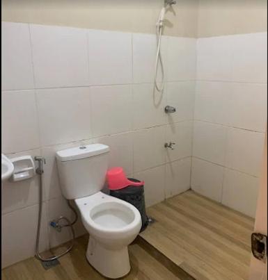 a bathroom with a white toilet in a room at Janisah Pension House in Narra