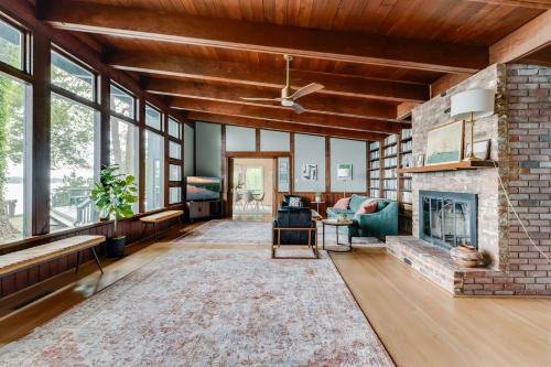 a living room with a brick fireplace and a ceiling fan at Scenic, Spacious Riverside Retreat Ropeyarn in Deltaville