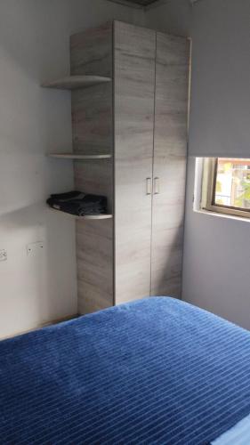 a bedroom with a blue bed and a cabinet at Apartamento completo Santa Rosa de Cabal in Santa Rosa de Cabal