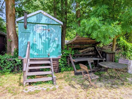 a blue shed with a ladder and a bench and a chair at Radler-Pension in Lübbenau