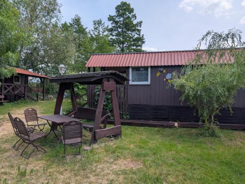 a picnic table and chairs in front of a house at Radler-Pension in Lübbenau