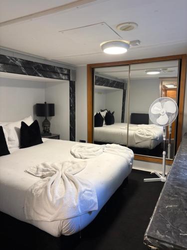 a bedroom with two beds and a large mirror at Winnie baygo Meadow view in Hurst