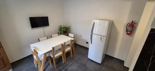 a kitchen with a white table and a refrigerator at Batilana 2 in Neuquén