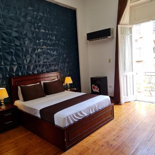 a bedroom with a large bed with a black wall at Kmt Hostel in Cairo