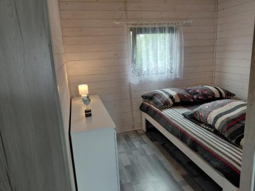 a small bedroom with a bed and a window at Wichrowa Skarpa in Rusinowo
