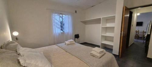 a bedroom with a large bed with towels on it at Batilana 2 in Neuquén