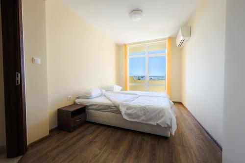 a small bedroom with a bed and a window at Къща за гости Вихрен-Сандански in Sandanski