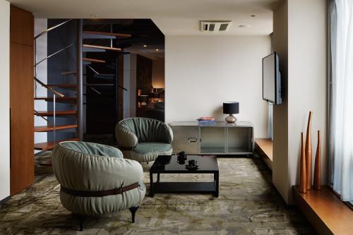 a living room with two chairs and a tv at Akasaka Granbell Hotel in Tokyo