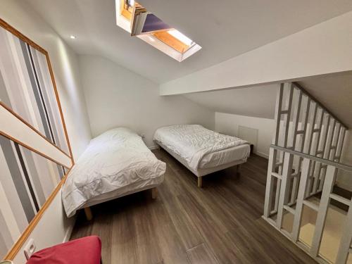 a small room with two beds and a window at Duplex moderne & calme à Malakoff in Malakoff