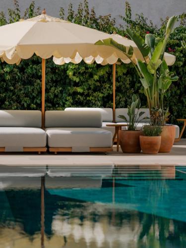ein Pool mit Liegestühlen und einem Sonnenschirm in der Unterkunft CASA METT Sitges - Fully refurbished in Sitges