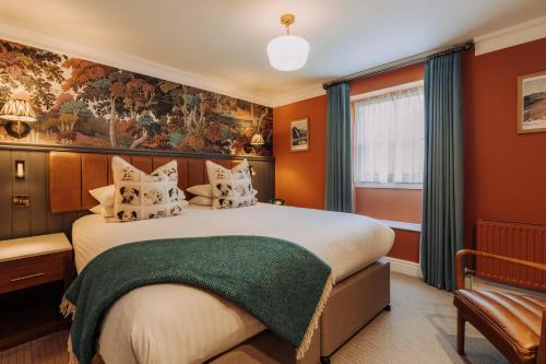 a bedroom with a large bed with orange walls at The Kings Arms Hotel in Keswick