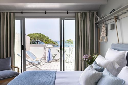 a bedroom with a bed and a view of a patio at Les Hautes Mers - Fontenille Collection in L'Ile d'Yeu