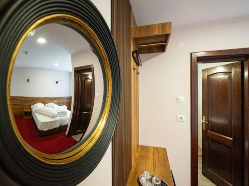 a mirror in a hotel room with a bed at Pensiunea Florica in Piteşti