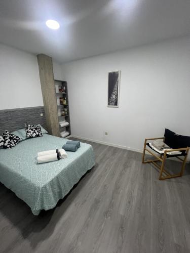 a bedroom with a bed and a chair at A&R Santiago de Compostela in San Sebastián de los Reyes