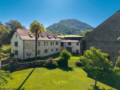 an old stone building with a palm tree in a yard at Chez Castagné in Issor