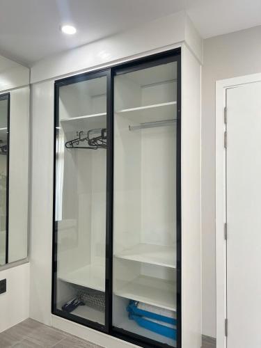 a glass cabinet with shelves in a room at La Vida Residences Villa in Ấp Phước Thánh