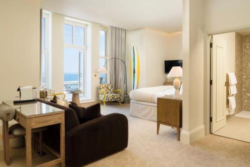 a hotel room with a bedroom with a bed and a couch at THE NICI Newquay in Newquay