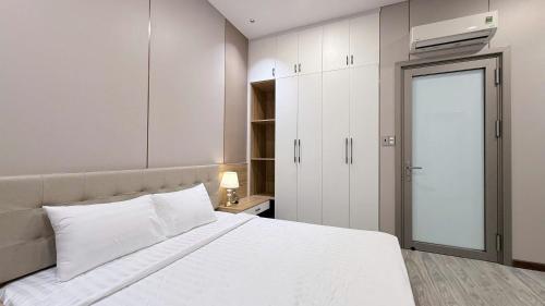 a bedroom with a large white bed and a closet at Viễn Dung Hotel in Buon Ma Thuot