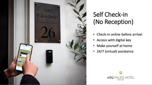 a person holding a cell phone in front of a door at ARQ Paleis Hotel in The Hague