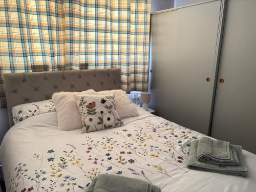 a bedroom with a bed with flowers on it at Retreat to the Chalet in Withernsea