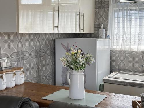a vase of flowers sitting on a table in a kitchen at Retreat to the Chalet in Withernsea