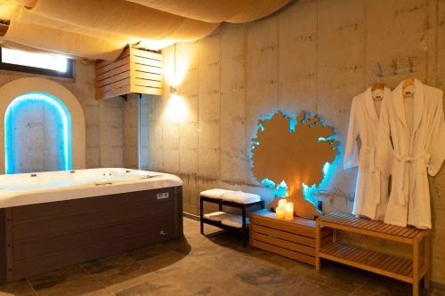 a bathroom with a tub and a robe on a wall at La Cantera Rural Spa in Viñaixa