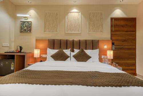 a bedroom with a large bed and two lamps at The Roseville Grand Near Chandigarh University-Rayat Bahra University Kharar Chandigarh in Kharar