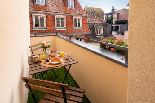 a table on a balcony with a breakfast on it at Nouveau - Le CityScape - Petite Venise in Colmar
