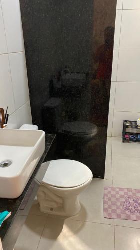 a bathroom with a white toilet and a sink at Casa completa com piscina 12min da praia in Porto Seguro